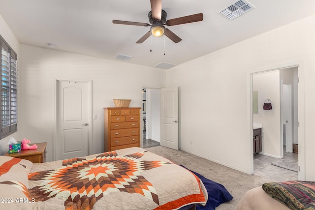 bedroom with ceiling fan, ensuite bathroom, and light carpet