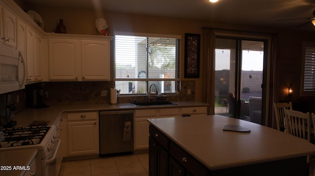 kitchen with sink, a kitchen island, a healthy amount of sunlight, and white appliances