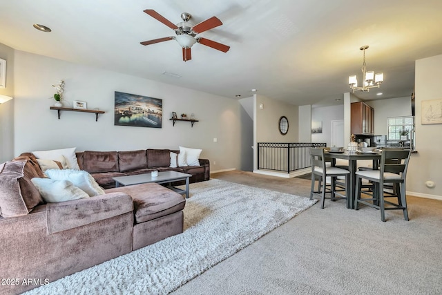 living area featuring baseboards, light colored carpet, and ceiling fan with notable chandelier