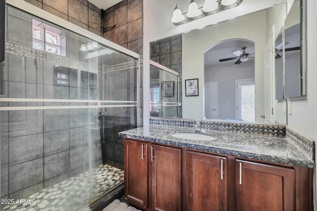 full bathroom with vanity, a shower stall, and ceiling fan