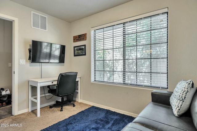 carpeted office space featuring visible vents and baseboards