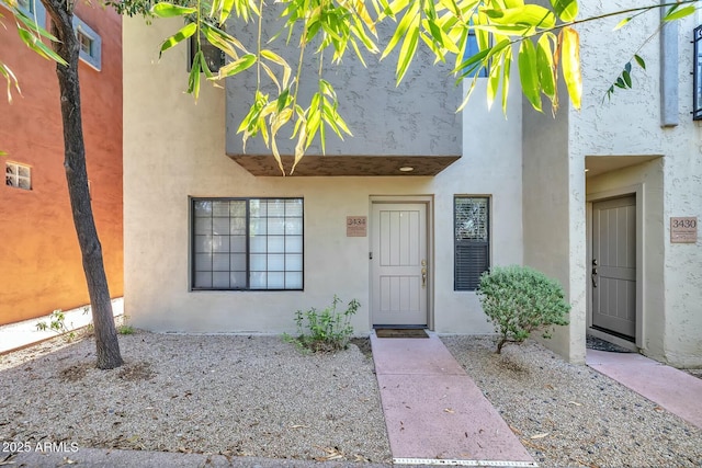 view of exterior entry featuring visible vents and stucco siding