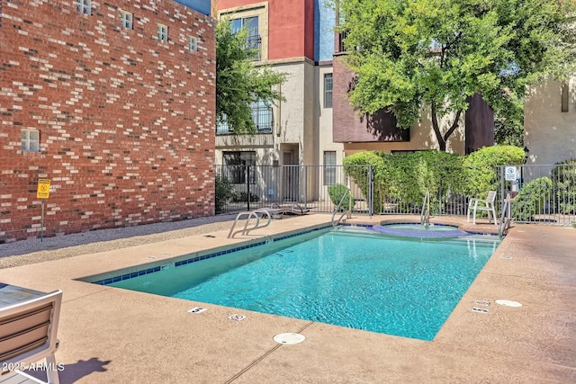 community pool with a patio and fence