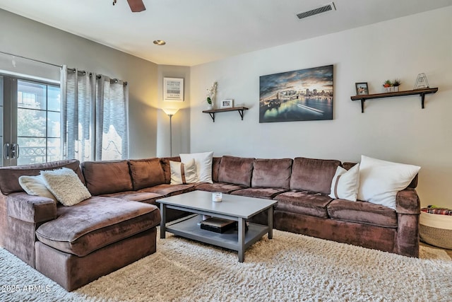 living area featuring visible vents and ceiling fan