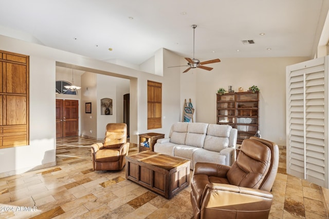 living room with a towering ceiling and ceiling fan with notable chandelier