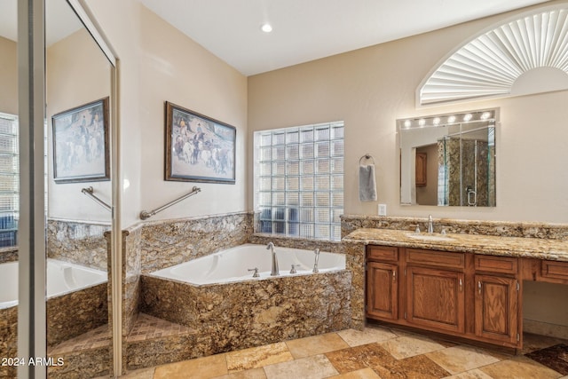 bathroom with vanity and shower with separate bathtub