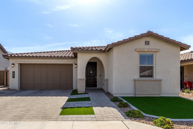 6931 W Spur Dr, Peoria, AZ 85383 - mediterranean / spanish house with a garage, a tiled roof, decorative driveway, and stucco siding