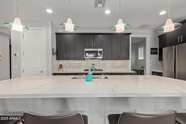 6931 W Spur Dr, Peoria, AZ 85383 - kitchen with stainless steel appliances, tasteful backsplash, a sink, decorative light fixtures, and recessed lighting