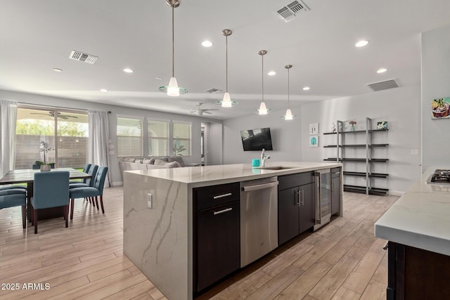 6931 W Spur Dr, Peoria, AZ 85383 - kitchen featuring ceiling fan, appliances with stainless steel finishes, light wood finished floors, a sink, and open floor plan