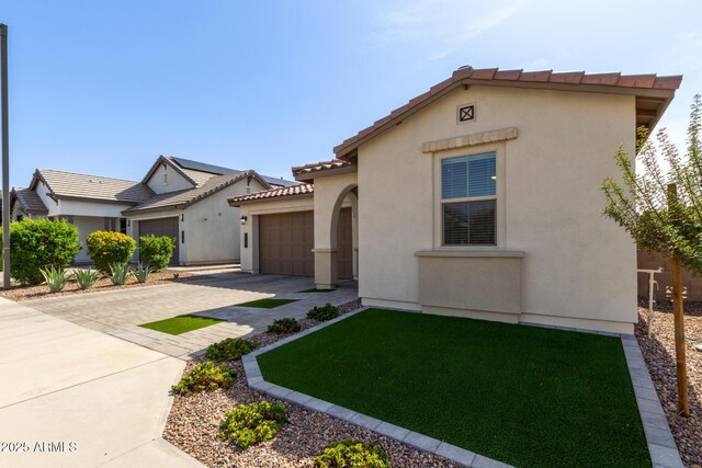 6931 W Spur Dr, Peoria, AZ 85383 - mediterranean / spanish home with decorative driveway, a garage, stucco siding, a tiled roof, and a front yard