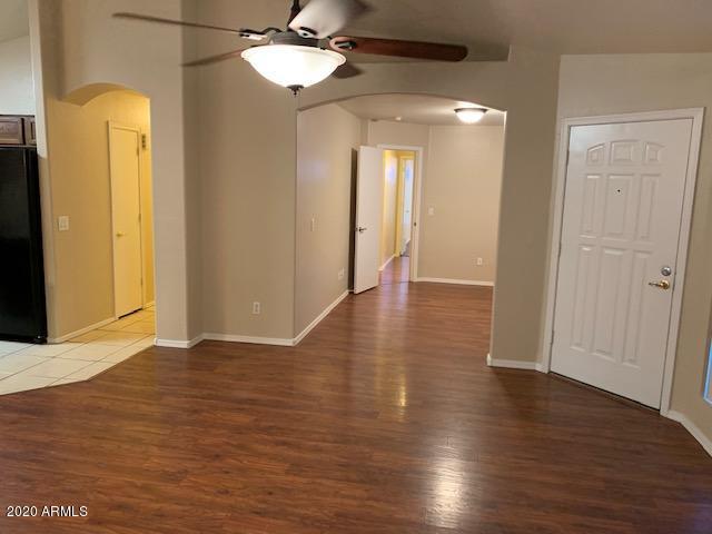 4533 E Glenhaven Dr, Phoenix, AZ 85048 - unfurnished room with arched walkways, a ceiling fan, wood finished floors, and baseboards