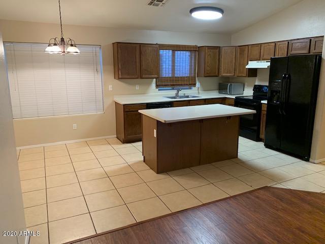 4533 E Glenhaven Dr, Phoenix, AZ 85048 - kitchen featuring black appliances, a sink, light countertops, exhaust hood, and a center island