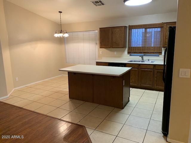 4533 E Glenhaven Dr, Phoenix, AZ 85048 - kitchen featuring a sink, light countertops, a chandelier, freestanding refrigerator, and a kitchen island