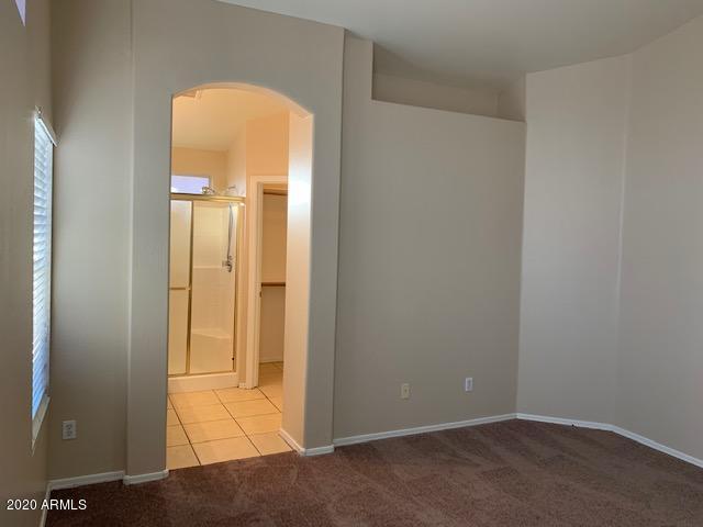 4533 E Glenhaven Dr, Phoenix, AZ 85048 - carpeted spare room with arched walkways, baseboards, and tile patterned floors