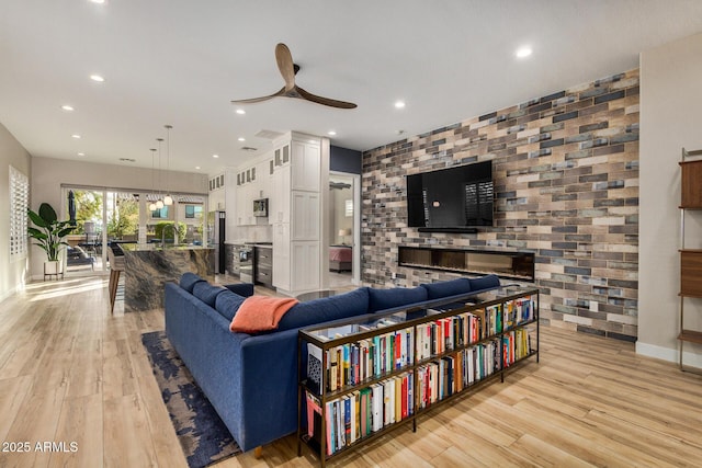 living room featuring light hardwood / wood-style flooring and ceiling fan