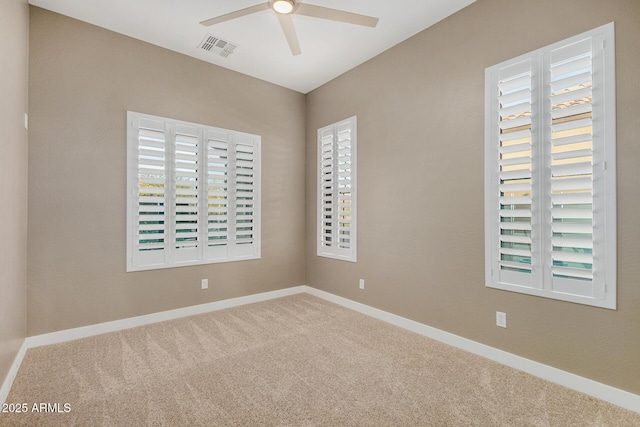 carpeted spare room with ceiling fan