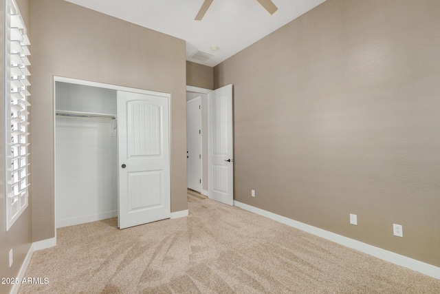 unfurnished bedroom with light carpet, ceiling fan, and a closet