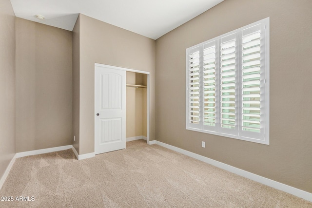 unfurnished bedroom featuring light colored carpet and a closet