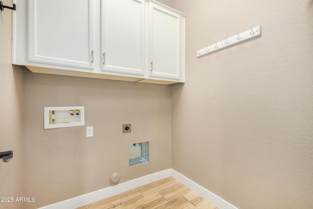 washroom with cabinets, hookup for a gas dryer, washer hookup, hookup for an electric dryer, and light wood-type flooring