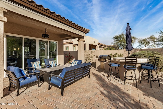 view of patio with area for grilling, exterior bar, outdoor lounge area, and ceiling fan