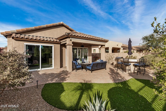 back of property featuring a patio, outdoor lounge area, ceiling fan, and a bar