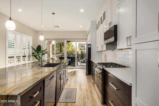 kitchen with white cabinetry, appliances with stainless steel finishes, sink, and pendant lighting