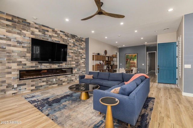 living room with light hardwood / wood-style flooring and ceiling fan