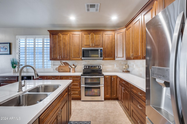 kitchen featuring light tile patterned flooring, stainless steel appliances, backsplash, and sink