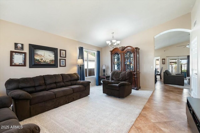 living room featuring lofted ceiling, light tile patterned floors, ceiling fan with notable chandelier, and a wealth of natural light