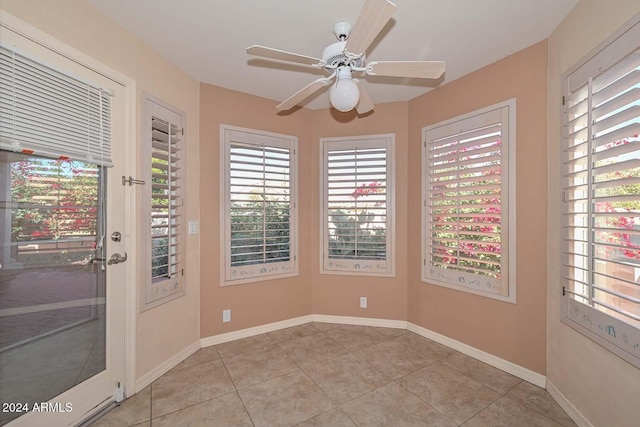 tiled spare room with ceiling fan