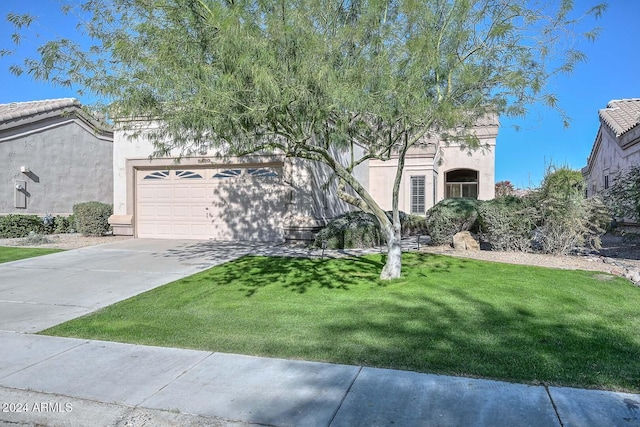 view of front of property with a front yard and a garage