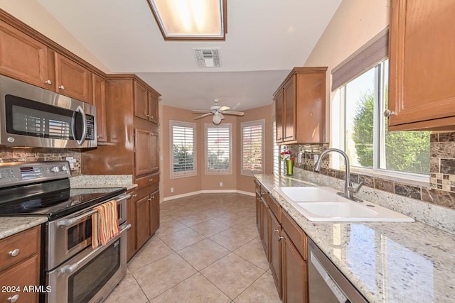 kitchen featuring decorative backsplash, appliances with stainless steel finishes, lofted ceiling, and sink