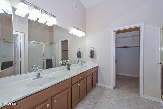 bathroom with tile patterned flooring, vanity, an enclosed shower, and vaulted ceiling