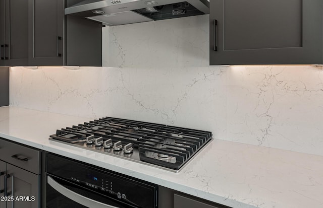 kitchen featuring extractor fan, wall oven, light stone countertops, decorative backsplash, and stainless steel gas stovetop