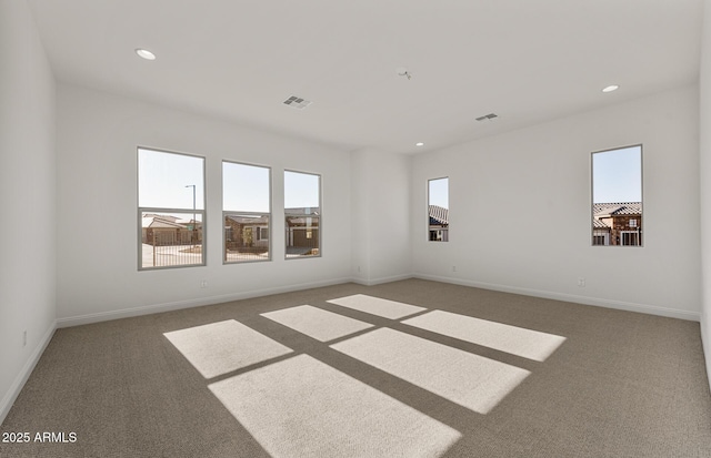 carpeted empty room featuring baseboards, visible vents, and recessed lighting