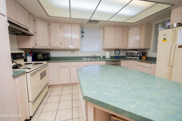 1565 E 12th St, Douglas, AZ 85607 - kitchen with stainless steel appliances, under cabinet range hood, light tile patterned floors, and dark countertops