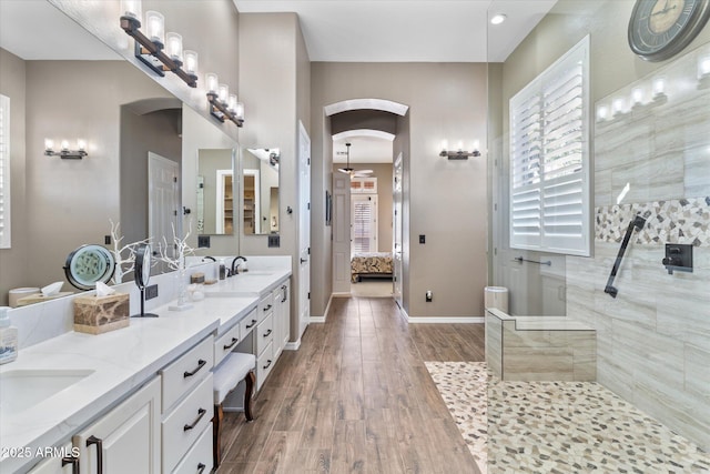 bathroom featuring hardwood / wood-style flooring, vanity, a wealth of natural light, and a tile shower