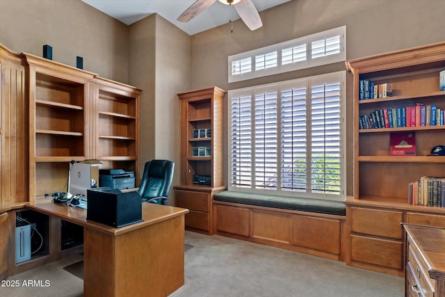 carpeted office space with ceiling fan