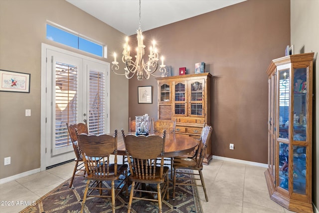 tiled dining area featuring a high ceiling, a notable chandelier, and french doors