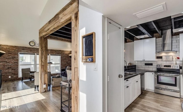 5621 N 79th St, Scottsdale, AZ 85250 - kitchen with stainless steel appliances, brick wall, wall chimney range hood, a sink, and light wood-type flooring