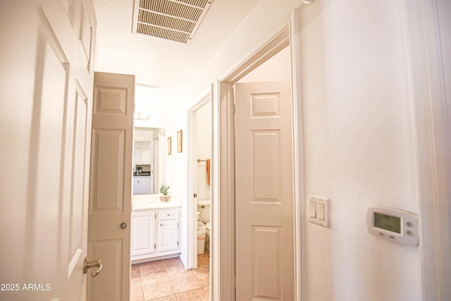 hallway with visible vents and light tile patterned flooring