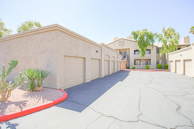 exterior space with community garages and stucco siding