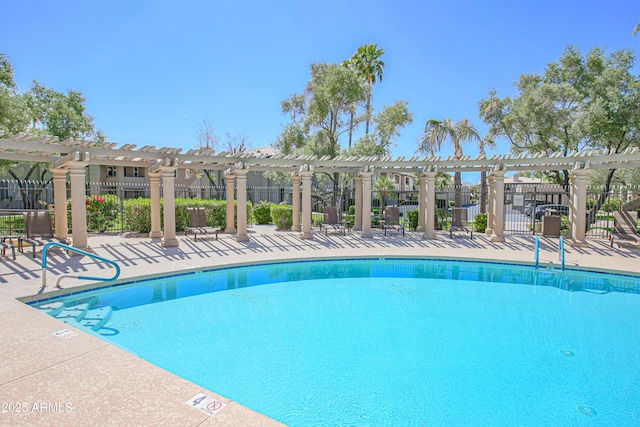 pool with a pergola, fence, and a patio area
