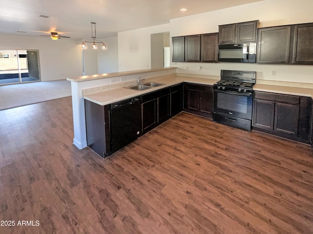 kitchen with sink, decorative light fixtures, dark hardwood / wood-style flooring, kitchen peninsula, and black appliances