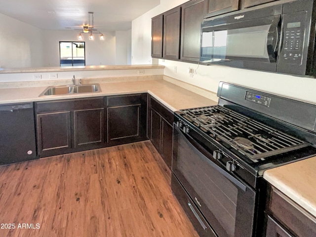 kitchen featuring sink, a wealth of natural light, light wood-type flooring, and black appliances