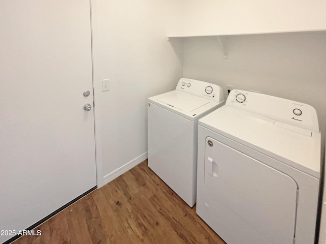 laundry area with wood-type flooring and washing machine and dryer