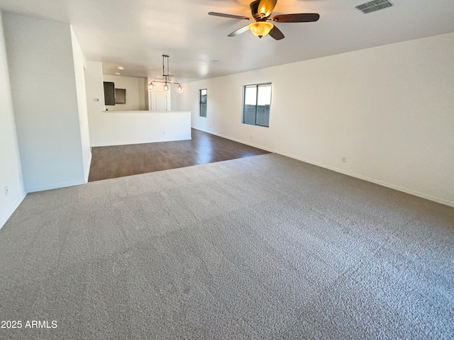 unfurnished living room with ceiling fan and dark colored carpet