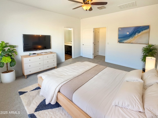 bedroom with ceiling fan, light colored carpet, and ensuite bathroom