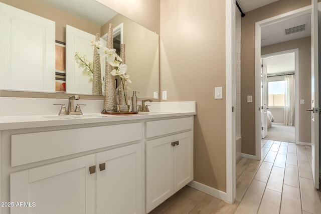 ensuite bathroom featuring a sink, double vanity, ensuite bath, and visible vents