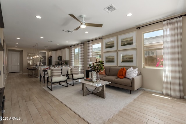 living room featuring light wood-style floors, visible vents, a ceiling fan, and recessed lighting